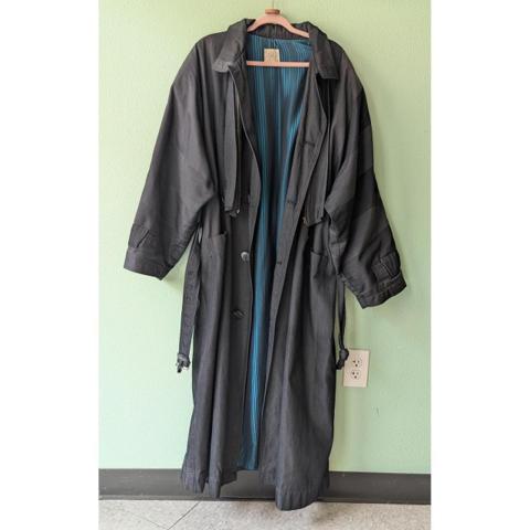 Vintage Arrston Volaju Kohshin Satoh Trench Coat Grey Teal Lining Large 80s

Vintage Arrston Volaju by Kohshin Satoh trench coat in a dark charcoal grey with a striking teal blue striped cupra lining. This Japanese designer piece features a long, oversized silhouette with a belted waist, adjustable cuff straps, and a classic collar. The fabric is a durable nylon and cotton blend with a subtle texture, while the interior showcases the high-quality craftsmanship Kohshin Satoh is known for. Functional details include deep side pockets and a button-front closure, making it a standout avant-garde addition to any wardrobe.

Good vintage condition from the 80s. There is a small tear in the inner lining seam and some light scuffing on the metal buckle, as shown in photos. Otherwise excellent.

Approx Measurements:
• Pit to Pit: 29" (52" chest)
• Length: 52"
• Sleeve Length: 19.5"

#80s #designer #arttowear #AvantGarde #Vintage