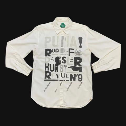 2000s PUMA Rudolf Dassler Schuhfabrik 'Art Review' Button Down Shirt by Futurenet Milano SRL • RARE

• INFO: A relaxed fitting oxford shirt sold only through PUMA's Black Station flagship stores. Almost looks like it reads "RUDE ASSED KUNT" if you squint. Very well made, with a slightly grungy DIY-flair to it. Reminds me of some of Xuly Bët's work around the mid-90s.

• SIZING: Tagged adult size large, fits like a ladies' 1X. Roughly 21.5 inches from pit to pit. 29 inch front length, 30 inch back length. 

• CONDITION: Preowned. Fully intact with a few small reddish spots (slide 5) that could be easily removed by a dry cleaner. In pretty good shape overall for being about 20 years old.

• FEATURES: 100% cotton oxford knit. Hidden button-front closure. Mother-of-pearl buttons. Bowed waist hem. Straight soft collar. Screen printed fromt graphic.

#hoodbyair #indie #xulybet #puma #buttondown