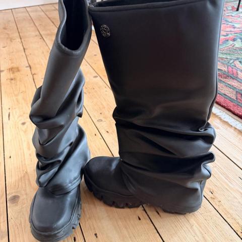 Barely worn, amazing quality Rombaut Typhoon black rubber boots size UK 6 / EU 39.  This size sold out online, RRP €559! 

https://rombaut.com/products/typhoon-black-bamboo?variant=49732565336395&country=BE&currency=EUR&utm_source=google&utm_medium=cpc&utm_campaign=google_shopping&pmax-google-ads&tw_source=google&tw_adid=&tw_campaign=18900430790&tw_kwdid=&gad_source=1&gad_campaignid=18902544639&gbraid=0AAAAApC6qSkIpS9jq-mj6EWQeFCW_htu9&gclid=CjwKCAjwhZDUBhBGEiwAbi5bjt8dc2dLvJpUCXjI2XVE29PKWf75djjOZqsg7qGj4T552B7M9r7RkRoCm7oQAvD_BwE 

Black knee-high rain boots with a sleek, modern design. Waterproof, slip-resistant, and great for rainy weather. #rainboots #waterproof #grunge
