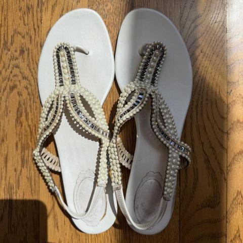 René Caovilla white pearl and silver beaded leather sandals. Scuffing along the front of shoes, soles show wear, and the glue has turned yellow in places. Missing one pearl (see last photo). Retails for $1500. 

Details: 
- Size: IT 40 / US 9.5
- Leather 
- Crystal and pearl embellished
 
#renecaovilla #designer #designersandals #vacation #summer